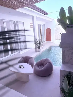 a living room with a pool with a table and chairs at Villa Grand in Sanur