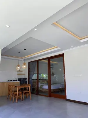 a dining room with a table and a bedroom at Villa Damai in Sanur