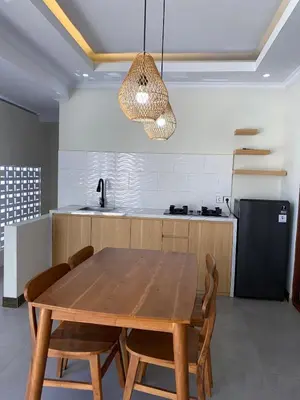 a kitchen with a wooden table and aendant light at Villa Damai in Sanur