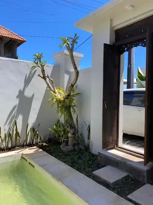 a door to a house with a tree in front of it at Villa Damai in Sanur