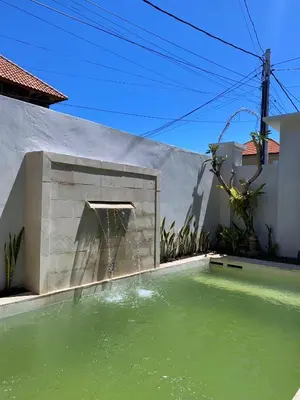 a water fountain in the courtyard of a house at Villa Damai in Sanur