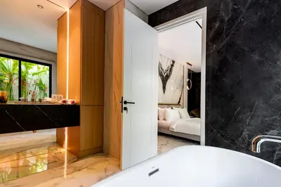 a bathroom with a tub and a bedroom at Anoya Boutique Villa in Kerobokan