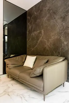 a leather couch in a room with a wall at Anoya Boutique Villa in Kerobokan