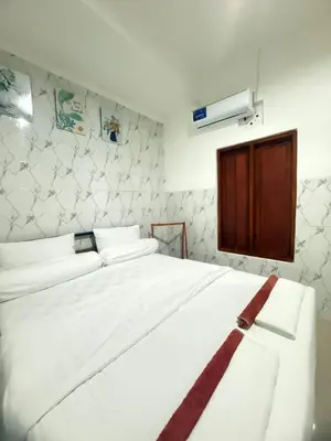 a bedroom with a white bed with a red ribbon on it at Private Room In Bali 10Mints To Sanur Beach in Sanur