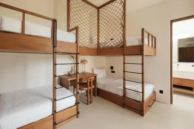 a bedroom with bunk beds with a desk and a bed at Manu Villas in Sanur