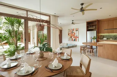 a dining room and living room with a table and chairs at Manu Villas in Sanur