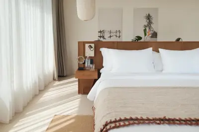 a bedroom with a large bed with white pillows at Manu Villas in Sanur
