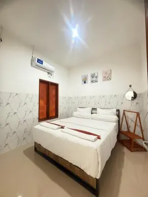 a bedroom with a large bed with aperature at Private Room Near Sanur Beach Bali in Sanur