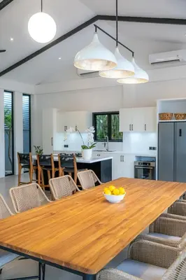 a kitchen and dining room with a wooden table and chairs at Villa Seminyak Beachside Luxury in Seminyak