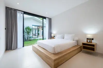 a bedroom with a bed and a large window at Villa Seminyak Beachside Luxury in Seminyak
