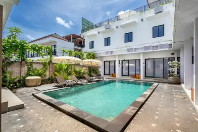 a swimming pool in front of a building at Uma Katani in Jimbaran