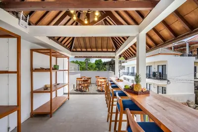 an open kitchen and dining room with a long table and chairs at Uma Katani in Jimbaran