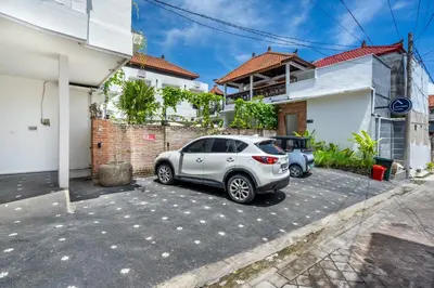 a white car parked in a parking lot in front of a house at Uma Katani in Jimbaran
