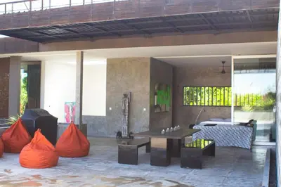 an outdoor patio with a table and chairs and a couch at Modern 4BD Villa with Pool in Seminyak