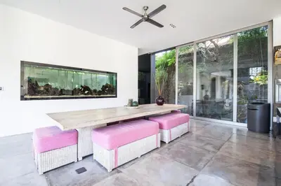 a dining room with a wooden table and pink stools at Modern 4BD Villa with Pool in Seminyak
