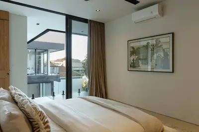 a bedroom with a bed and a large window at Ultra-Luxe 4BR Seminyak Villa - Indoor AC Living & Private Pool in Seminyak