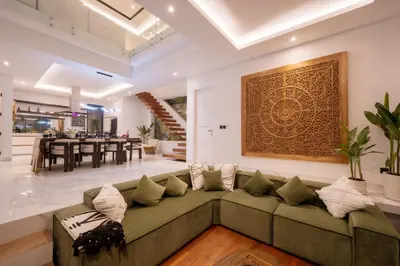 a living room with a green couch and a dining room at Villa Samyati Kerobokan in Seminyak