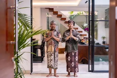 a man and woman standing in a room with their hands in prayer at Villa Samyati Kerobokan in Seminyak