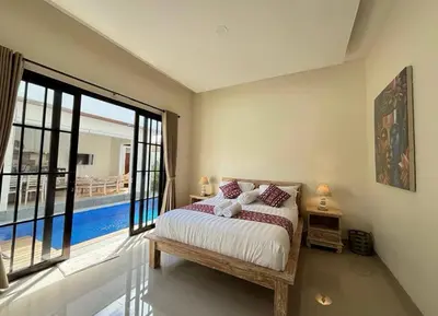 a bedroom with a bed and a large window at FrangipaniVilla in Seminyak