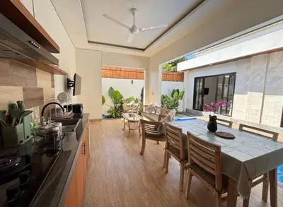a kitchen and dining room with a table and chairs at FrangipaniVilla in Seminyak