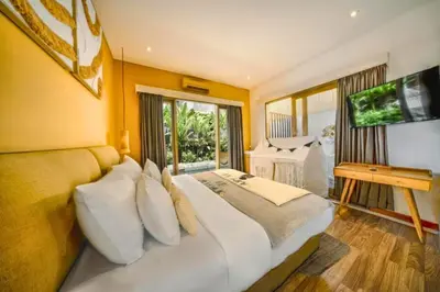 a bedroom with a large bed and a television at Teagan Pretty 1 BR Royal Private Pool Villa With Waterslide in Kerobokan