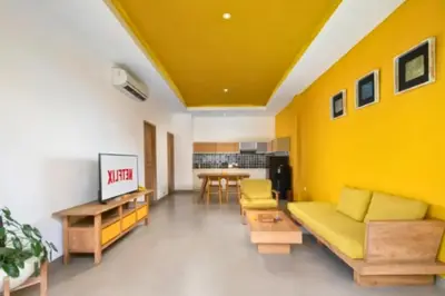 a yellow living room with a couch and a table at Teagan Pretty 1 BR Royal Private Pool Villa With Waterslide in Kerobokan