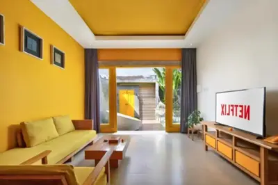 a living room with a couch and a tv at Teagan Pretty 1 BR Royal Private Pool Villa With Waterslide in Kerobokan