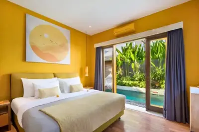 a bedroom with a bed and a view of a pool at Tindra Stunning 2 BR Royal Private Pool Villa With Waterslide in Kerobokan