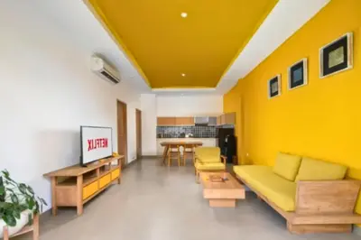 a living room with yellow walls and a couch and a table at Tindra Stunning 2 BR Royal Private Pool Villa With Waterslide in Kerobokan