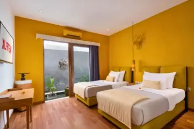 two beds in a room with yellow walls at Tindra Stunning 2 BR Royal Private Pool Villa With Waterslide in Kerobokan