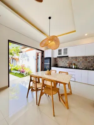 a dining room with a table and chairs in a kitchen at Casa Da Luca Beachside Sanur in Sanur