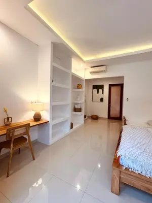 a bedroom with a desk and a bed and a table at Casa Da Luca Beachside Sanur in Sanur