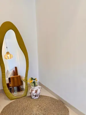 a vase sitting on a ottoman in front of a mirror at Casa Da Luca Beachside Sanur in Sanur