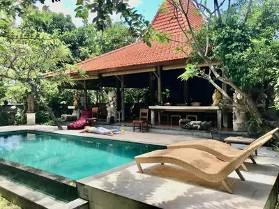 a person laying on the ground next to a swimming pool at The Secreet Garden Hotel in Denpasar