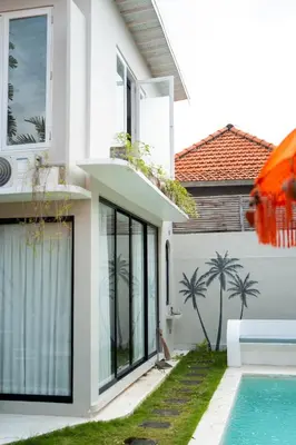 a white house with a swimming pool in front of it at Charming 3 BR villa in the heart of Umalas in Canggu