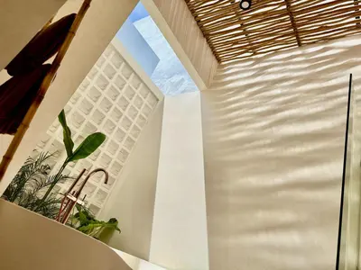 a staircase in a house with a large window at House of Rakiki Legian - 2BR Private Pool Villa in Central Legian close to Beach in Legian