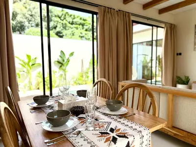 a dining room table with chairs and a tablecloth on it at House of Rakiki Legian - 2BR Private Pool Villa in Central Legian close to Beach in Legian