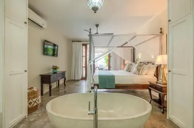 a bathroom with a tub and a bedroom with a bed at Seminyak Pool Villa in Seminyak