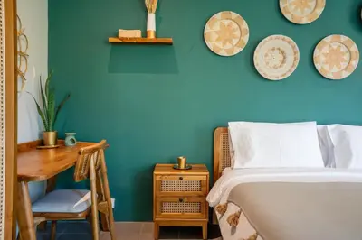 a bedroom with a blue wall with a bed and a desk at Casa Oliva - Tropical Pool Villa on Trendy Seminyak Eat Street in Seminyak