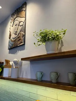 a shelf with a painting of a face on the wall at Casa Oliva - Tropical Pool Villa on Trendy Seminyak Eat Street in Seminyak