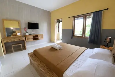a bedroom with a large bed and a fireplace at Palm 57 Guest House Legian in Legian
