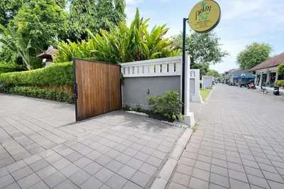 a wooden gate on a sidewalk next to a street at Palm 57 Guest House Legian in Legian