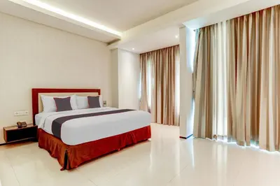 a bedroom with a bed and a large window at Collection O Legian Near Pantai Kuta Formerly Premium Legian in Legian