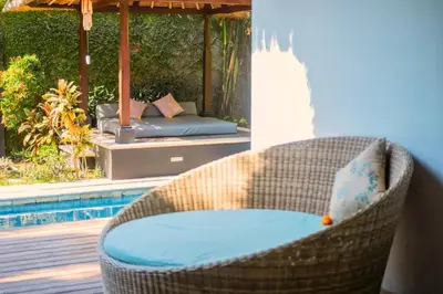 a wicker chair sitting next to a pool at Malaya Stunning 1 BR Private Pool Villa With Bathtub in Seminyak