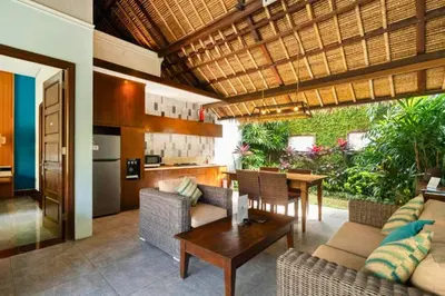 a kitchen and living room with a table and chairs at Malayna Comfortable 2 BR Royal Private Pool Villa in Seminyak