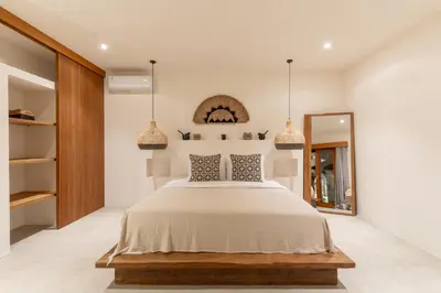 a bedroom with a large bed and a mirror at Villa Sora by Alfred in Bali in Seminyak