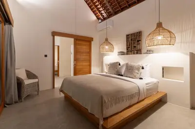 a bedroom with a bed and two pendant lights at Villa Sora by Alfred in Bali in Seminyak