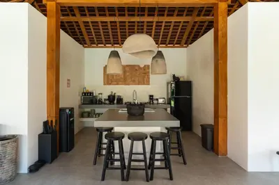 a kitchen with a table and stools at Villa Sora by Alfred in Bali in Seminyak