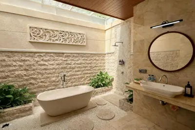 a bathroom with a tub and a sink and a mirror at Emstaliese & Palmarosa Villas Seminyak in Legian