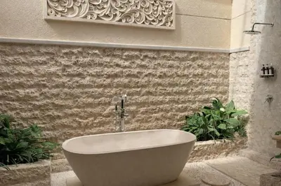 a bath tub in a bathroom with plants at Emstaliese & Palmarosa Villas Seminyak in Legian